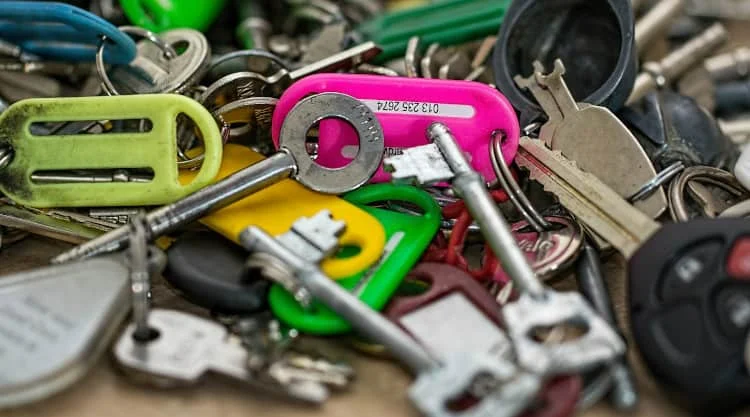 Eine Nahaufnahme eines Stapels sortierter Schlüssel und bunter Plastikschlüsselanhänger.