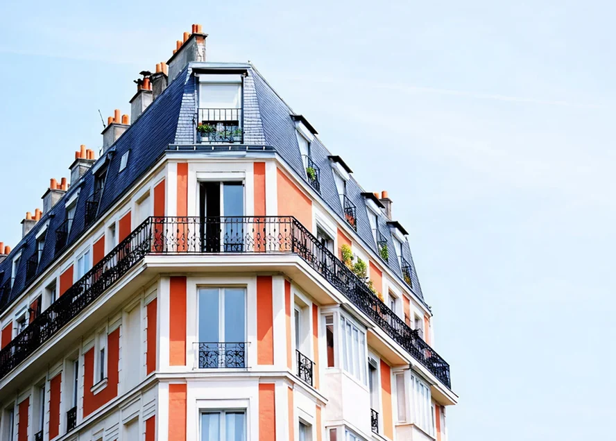 Elegantes Altbauhaus mit Mansarddach, Fensterläden und verzierten Balkongeländern