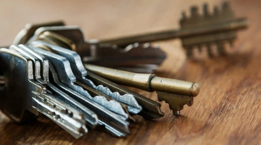 Eine Nahaufnahme von mehreren verschiedenen Metallschlüsseln auf einer Holzoberfläche.