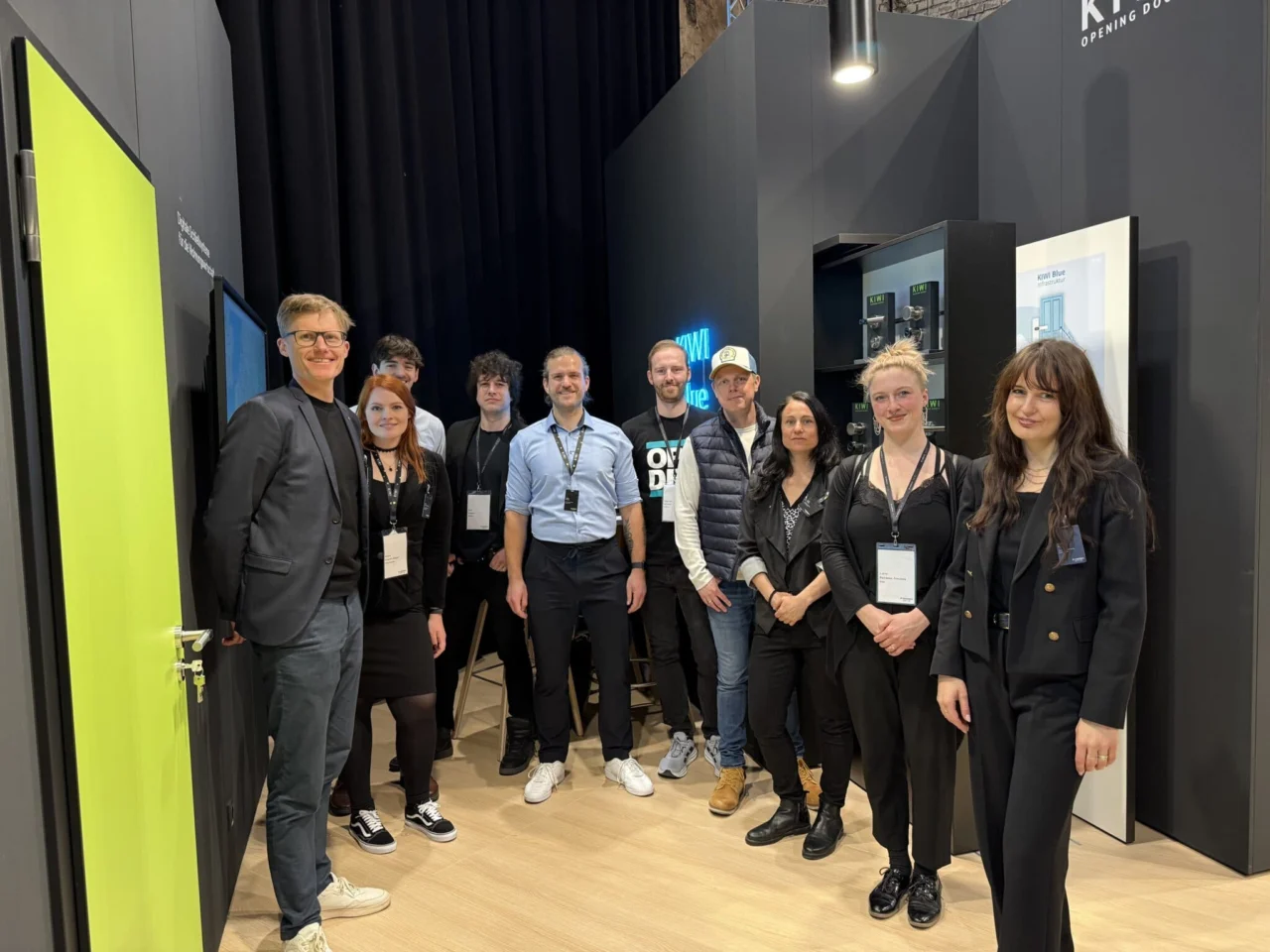 Team von KIWI beim Messeauftritt – das Team steht gemeinsam am Stand mit Produkten und Displays im Hintergrund und repräsentiert das Unternehmen professionell vor Ort.