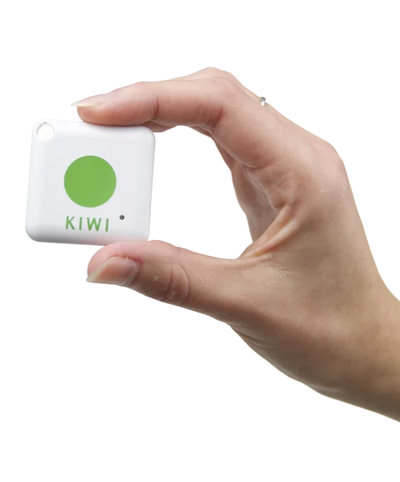Hand hält einen weißen KIWI-Transponder mit grünem Punkt – kontaktloses Gerät für den digitalen Gebäudezutritt.