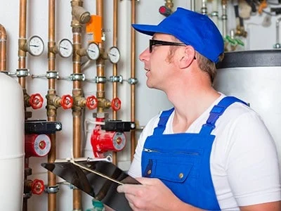 Handwerker im Heizungskeller mit einem Tablet
